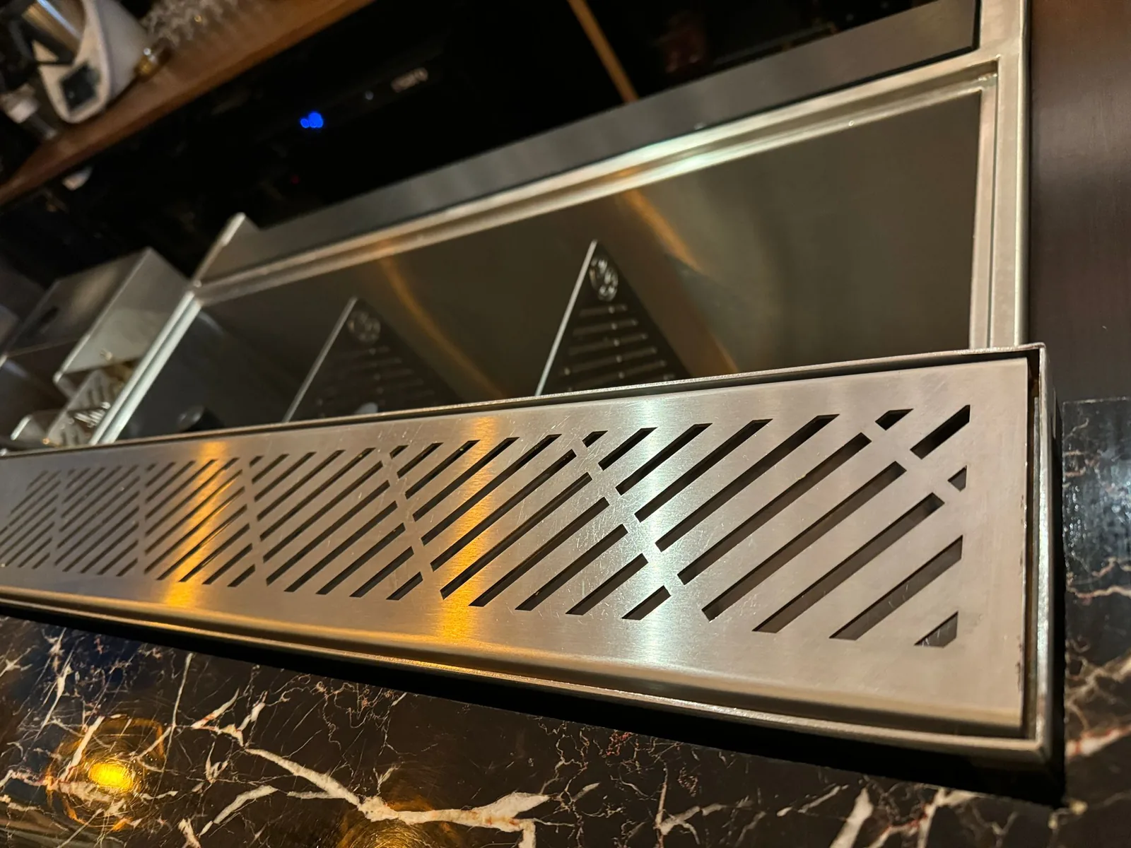 Bartender pouring at a stainless steel drink rail